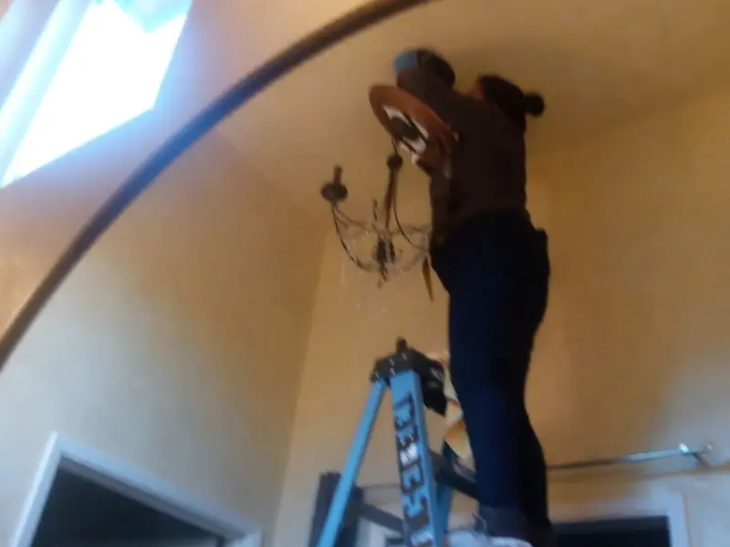 Electrician installing a chandelier in a Belgrade residence